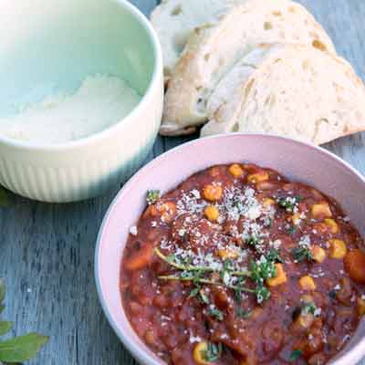 Tomatenrisotto noch mit Parmesan bestreuen und dazu Baguette